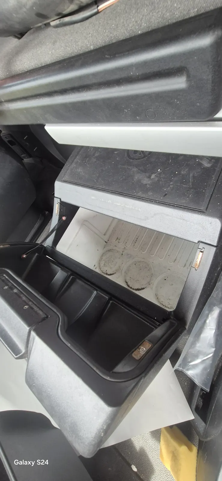 Rangements ouverts d'une cabine de camion avant nettoyage, avec des traces de dépôts au fond d'un bac