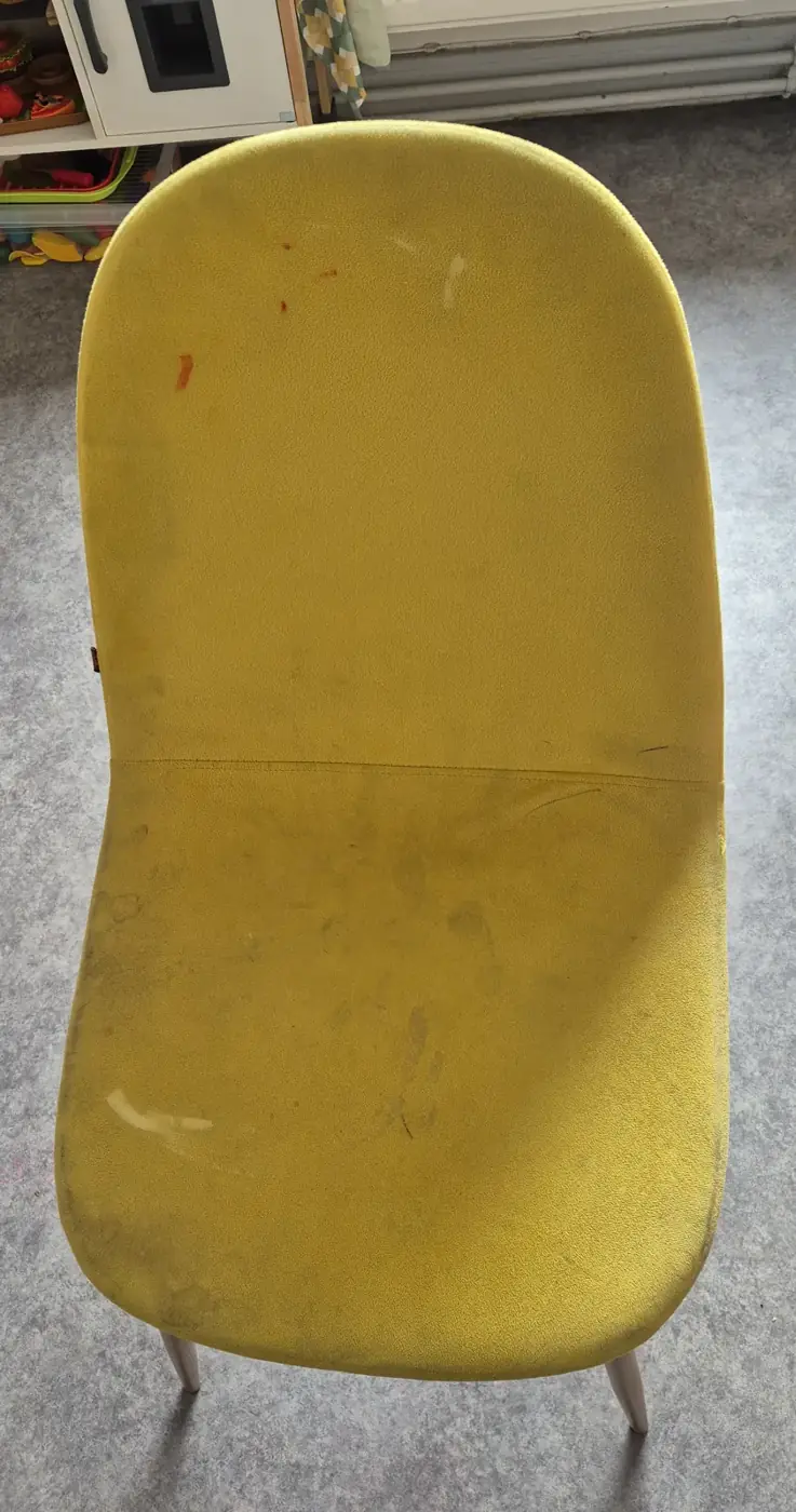 Chaise en tissu jaune avant nettoyage, taches orange sur le dossier et marques sur l’assise
